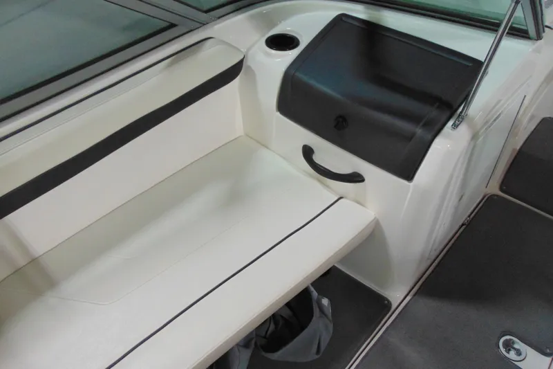 Slide: The Image of Interior seating of a 2016 Yamaha Boats AR190, featuring white upholstery and storage compartment. - 8