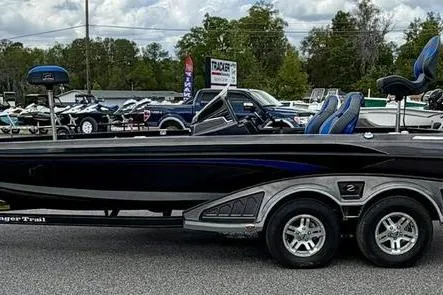 Slide: The Image of 2023 Ranger Z520R boat on trailer, parked outdoors with other boats in background. - 4