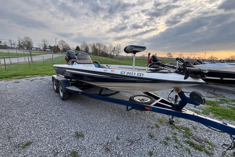 Slide: The Image of 2003 Champion 187 CX boat on trailer, parked on gravel, under cloudy sky. - 5