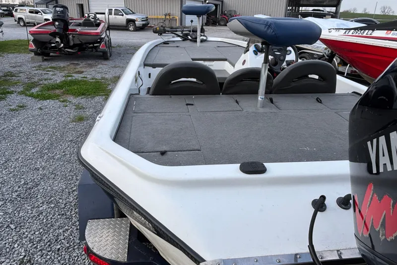 Slide: The Image of 2003 Champion 187 CX boat with Yamaha motor, parked on gravel lot. - 9