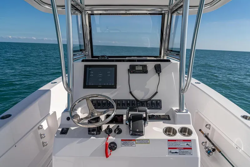 Slide: The Image of Manufacturer Provided Image: 2026 Twin Vee 260 STX CC boat console with steering wheel and ocean view. - 10