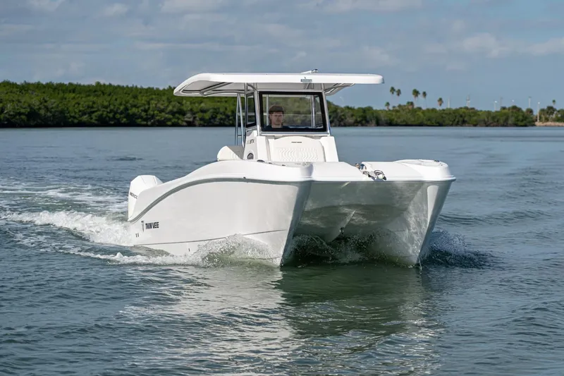 Slide: The Image of 2026 Twin Vee 260 STX CC catamaran cruising on calm waters. - 2