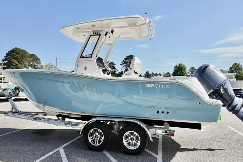 Slide: The Image of 2026 Sea Fox 228 Commander boat on trailer, light blue hull, parked outdoors. - 18