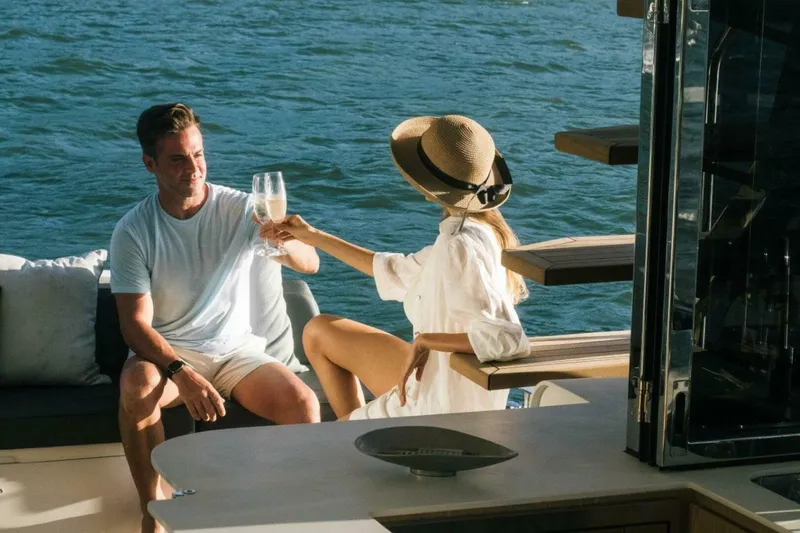 Slide: The Image of Couple enjoying drinks on a 2025 OKEAN 52 yacht, relaxing by the water. - 36