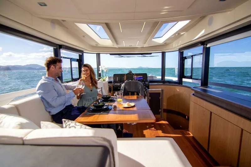 Slide: The Image of Couple enjoying a meal inside a luxurious 2025 OKEAN 52 yacht with ocean views. - 39