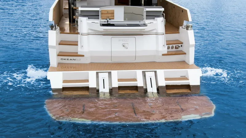 Slide: The Image of Luxury OKEAN 52 yacht, 2025 model, featuring a spacious rear deck on calm blue waters. - 7