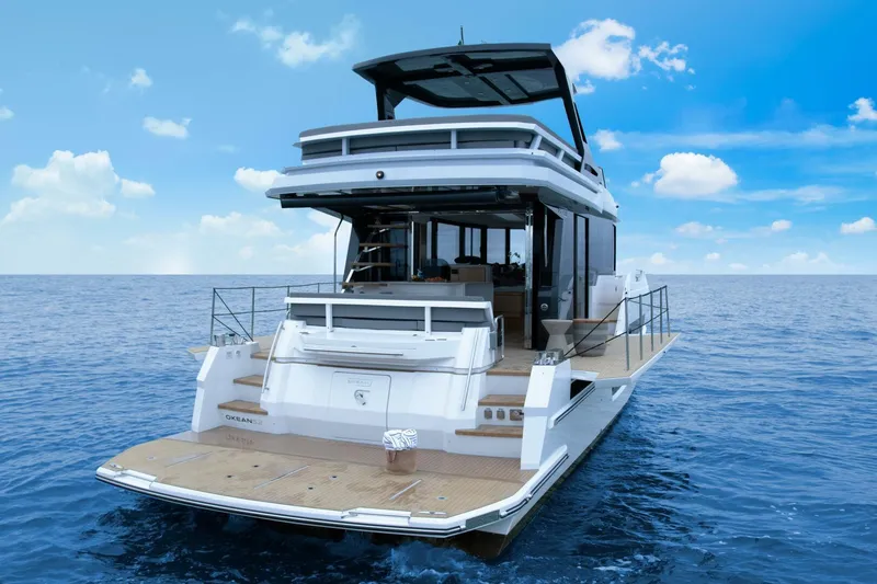 Slide: The Image of Luxury OKEAN 52 yacht cruising on open sea, 2025 model, under clear blue sky. - 8