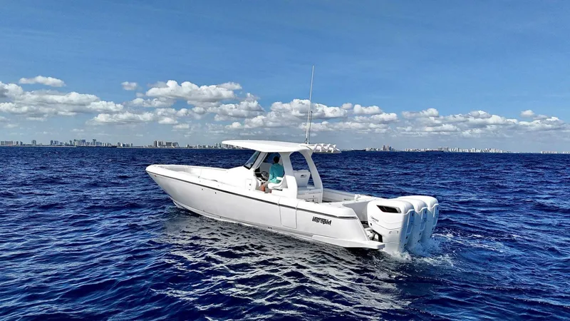 Slide: The Image of 2024 Intrepid 375 Nomad SE boat cruising on open ocean under clear blue sky. - 1