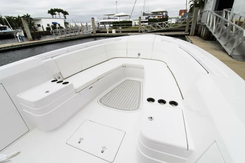 Slide: The Image of 2024 Intrepid 375 Nomad SE boat with spacious seating and sleek design at a marina. - 13