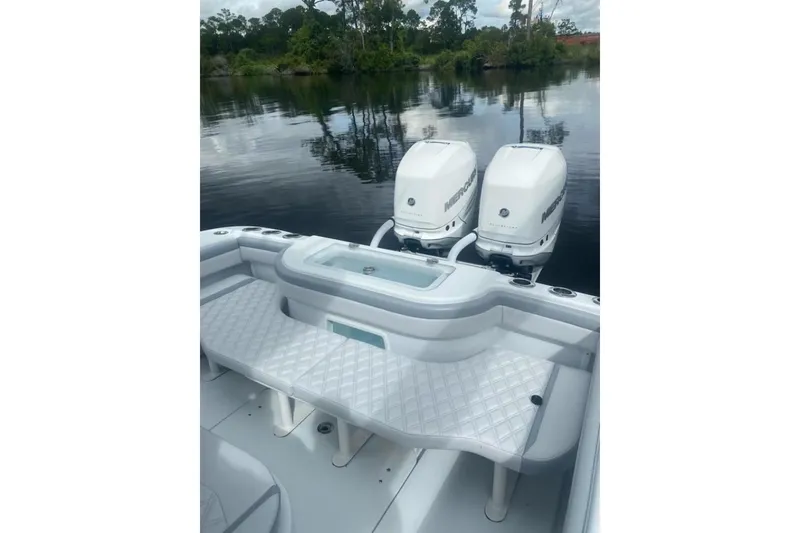 Slide: The Image of 2022 Yellowfin 32 boat with dual Mercury engines on a calm lake. - 4