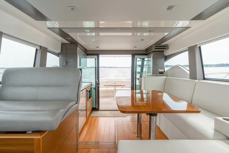 Slide: The Image of Interior of 2021 Tiara Yachts F44 Flybridge, featuring elegant seating and wooden table. - 25