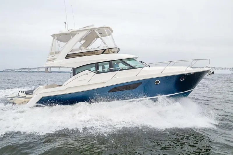 Slide: The Image of 2021 Tiara Yachts F44 Flybridge cruising on open water, showcasing sleek design and performance. - 3