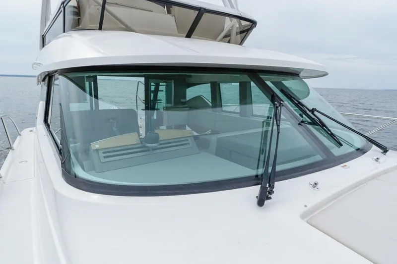 Slide: The Image of 2021 Tiara Yachts F44 Flybridge on open water, showcasing sleek design and windshield. - 46