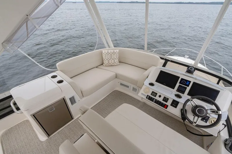 Slide: The Image of 2021 Tiara Yachts F44 Flybridge interior with helm, seating, and water view. - 53