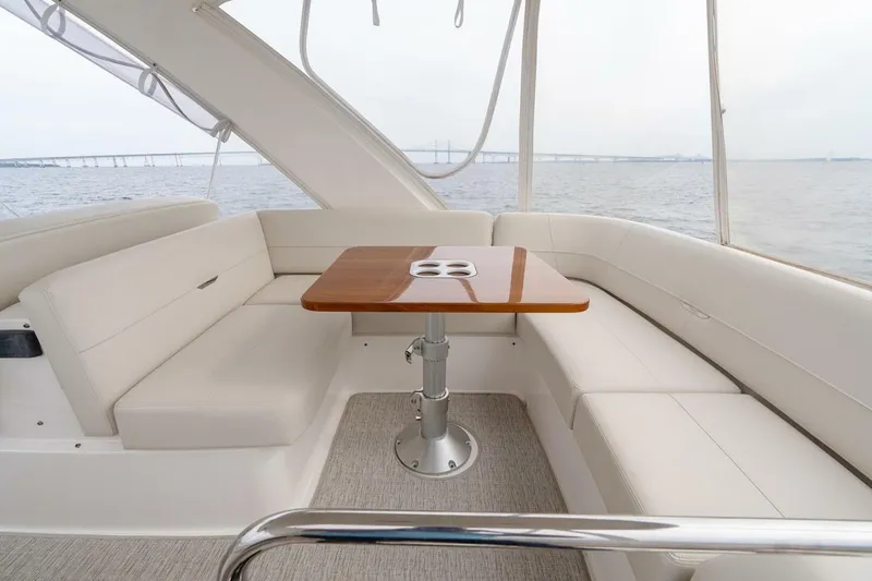 Slide: The Image of 2021 Tiara Yachts F44 Flybridge interior with elegant seating and wooden table. - 55