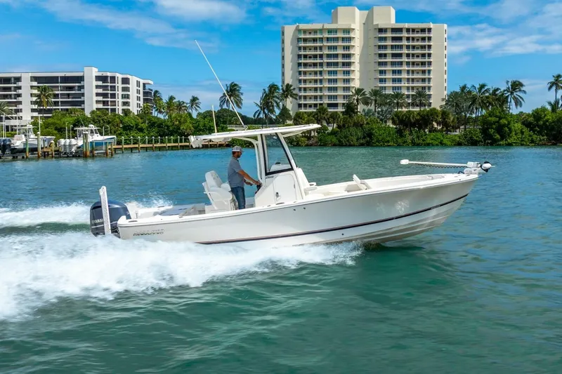 The Image of 2021 Regulator 26XO boat cruising on clear water near waterfront buildings. - 1