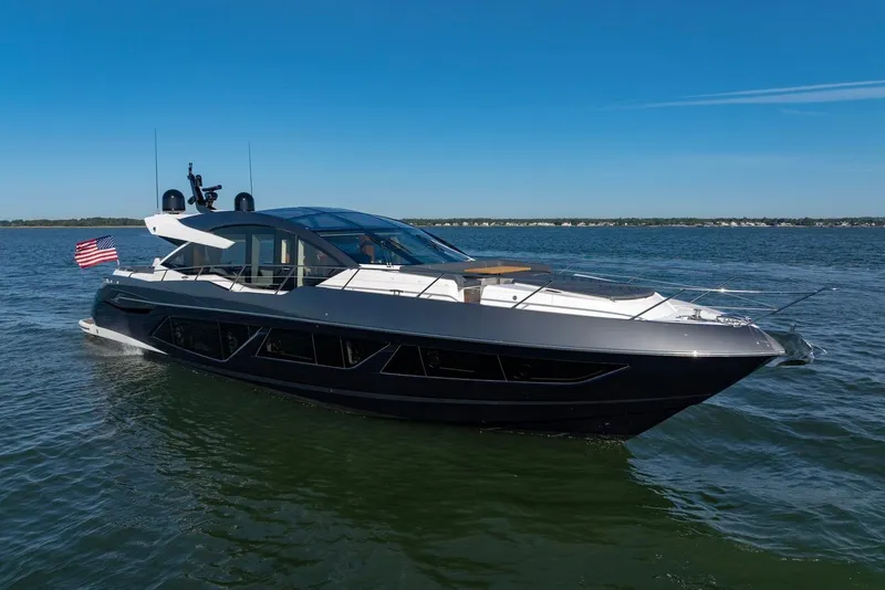 Slide: The Image of 2020 Sunseeker Predator 74 yacht cruising on open water under clear blue skies. - 6