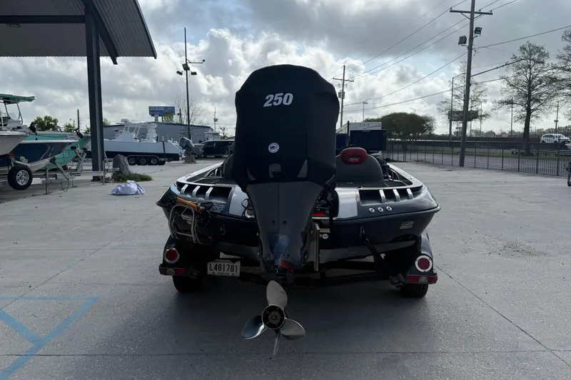 Slide: The Image of 2011 Ranger 521SVX Comanche boat with 250 HP motor in a parking lot. - 4