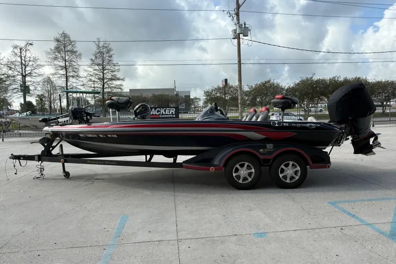 Slide: The Image of 2011 Ranger 521SVX Comanche boat on trailer, parked outdoors under cloudy sky. - 6