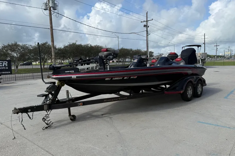 Slide: The Image of 2011 Ranger 521SVX Comanche boat on trailer, parked outdoors under cloudy sky. - 7