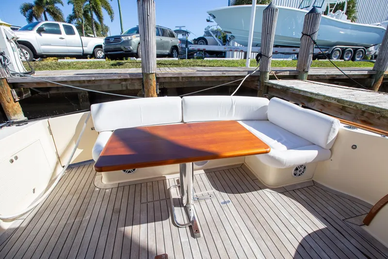 Slide: The Image of 2017 Palm Beach PB42 yacht deck with wooden table and white seating. - 11