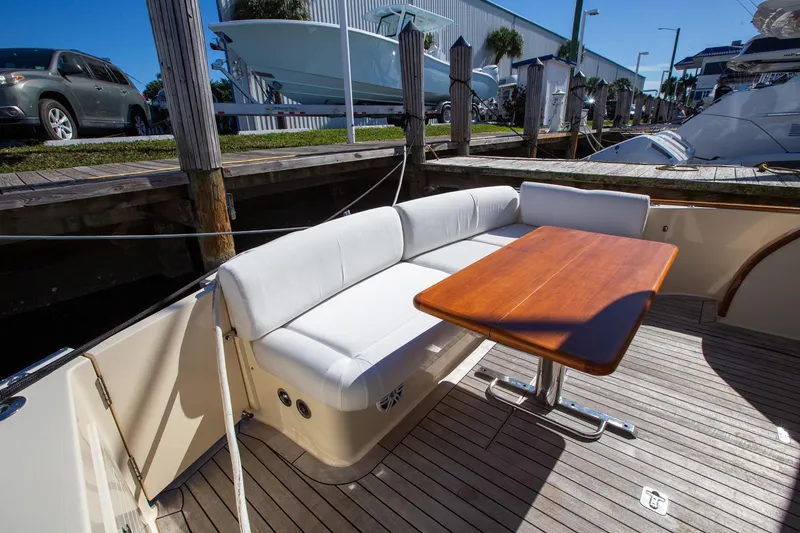 Slide: The Image of 2017 Palm Beach PB42 yacht with white seating and wooden table on deck. - 12