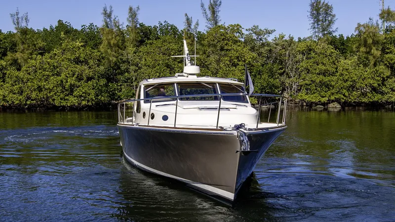 Slide: The Image of 2017 Palm Beach PB42 yacht cruising on a serene waterway. - 3