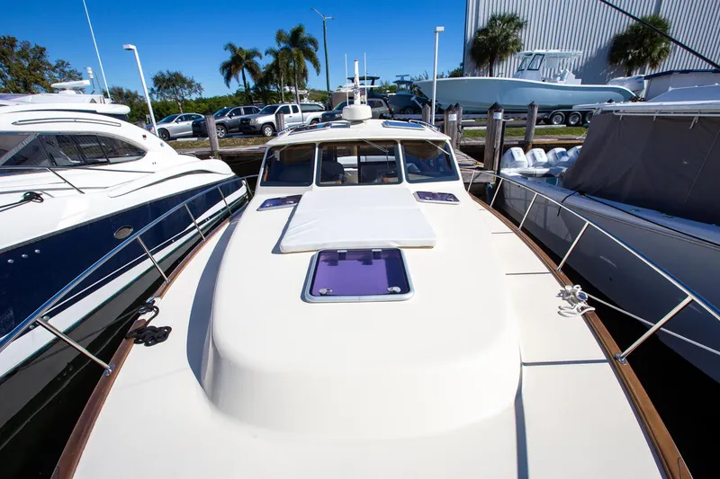 Slide: The Image of 2017 Palm Beach PB42 yacht docked, surrounded by other boats, under clear blue sky. - 6