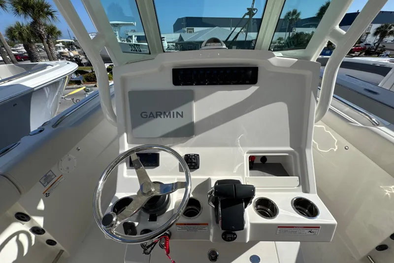 Slide: The Image of 2026 Sailfish 272 CC boat dashboard with Garmin navigation system and steering wheel. - 12