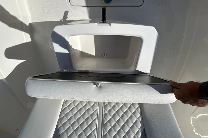 Slide: The Image of 2026 Sailfish 272 CC boat seat with storage compartment open, showcasing quilted upholstery. - 17