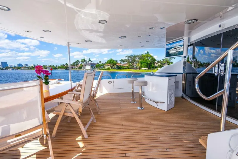 Slide: The Image of Luxurious 2008 Lazzara motor yacht deck with seating, bar, and scenic waterfront view. - 55