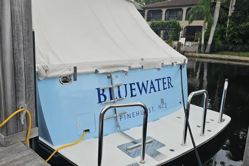 Slide: The Image of 2005 Ocean Alexander Raised Pilothouse Flybridge Sedan docked, featuring "BLUEWATER" name. - 2