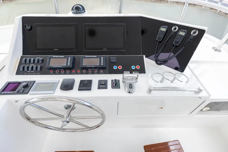 Slide: The Image of 2005 Ocean Alexander Raised Pilothouse Flybridge Sedan helm with navigation controls and steering wheel. - 21