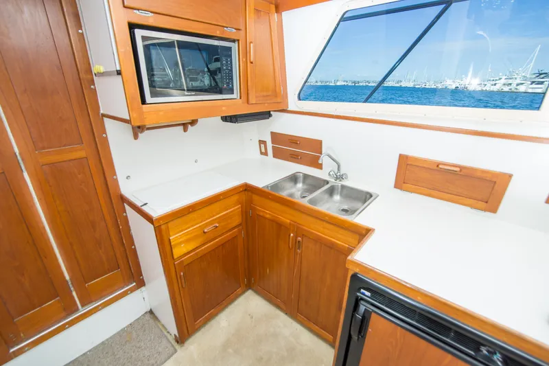 Slide: The Image of Interior of 1996 Blackman Sportfisher 32 boat kitchen with wooden cabinets and ocean view. - 22