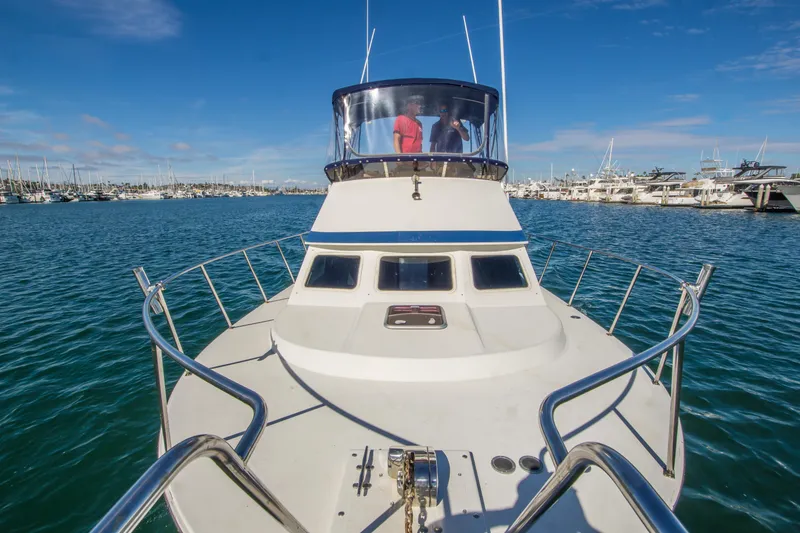 Slide: The Image of 1996 Blackman Sportfisher 32 boat on water, marina in background, clear blue sky. - 6