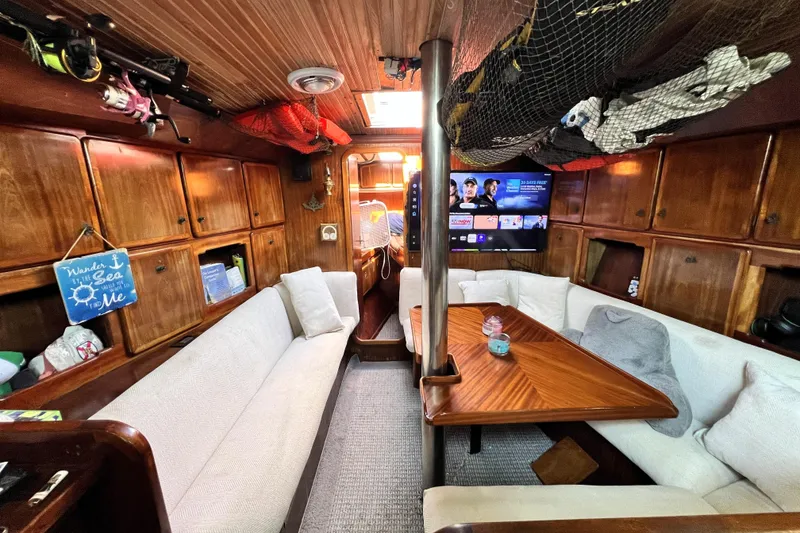 Slide: The Image of Cozy 1985 Pinical 14-34 yacht interior with wood paneling and comfortable seating. - 12