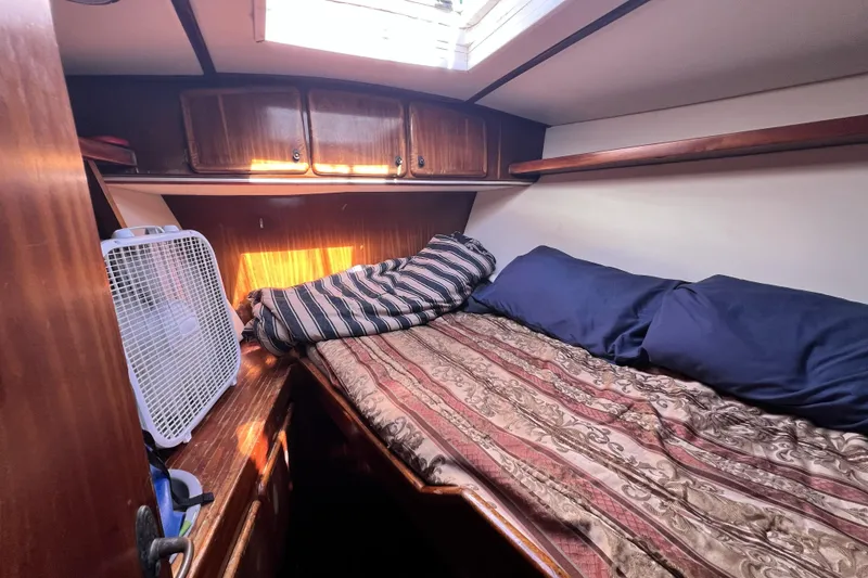 Slide: The Image of Cozy cabin interior of 1985 Pinical 14-34 boat with bed and fan. - 14