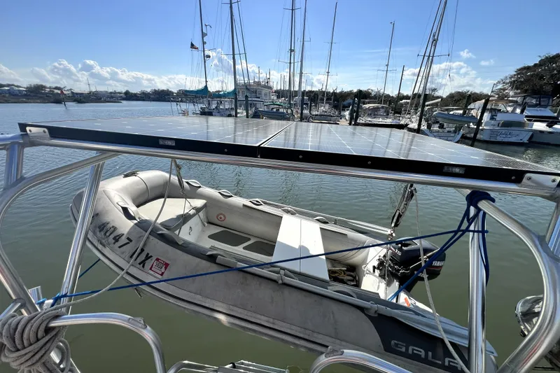 Slide: The Image of A 1985 Pinical 14-34 boat with solar panels and a dinghy in a marina. - 15