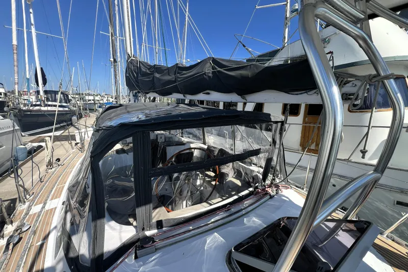 Slide: The Image of 1985 Pinical 14-34 sailboat docked at marina, featuring covered cockpit and steering wheel. - 17