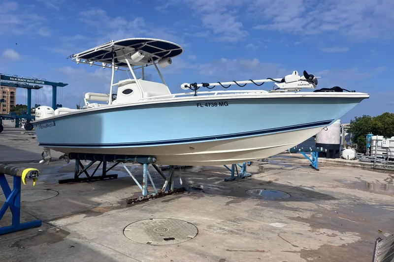 The Image of 2003 Island Runner 26 Center Console boat on dry dock under clear blue sky. - 1