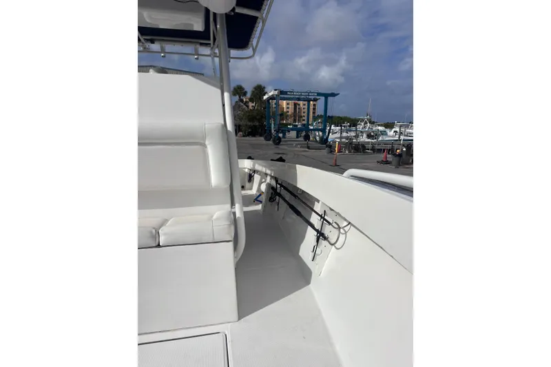 Slide: The Image of 2003 Island Runner 26 Center Console boat interior at marina, featuring seating and rod holders. - 11