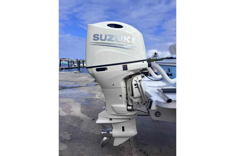 Slide: The Image of Suzuki outboard motor on a 2003 Island Runner 26 Center Console boat, dockside view. - 16