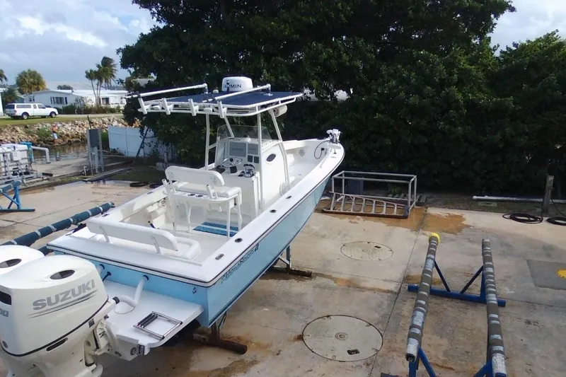 Slide: The Image of 2003 Island Runner 26 Center Console boat with Suzuki engines on a dock. - 5