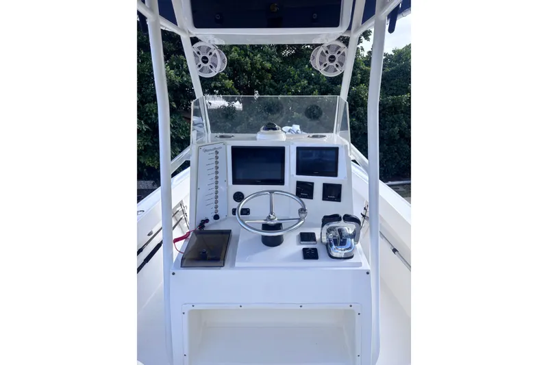 Slide: The Image of 2003 Island Runner 26 Center Console boat dashboard with steering wheel and navigation screens. - 7