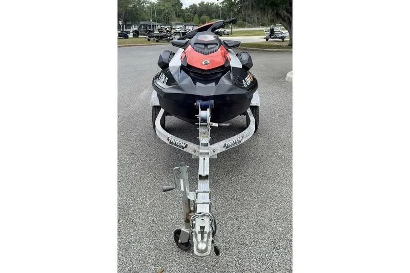 Slide: The Image of 2022 Sea-Doo GTI SE 130 jet ski on trailer, parked outdoors. - 2