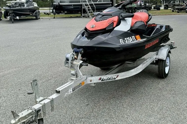 Slide: The Image of 2022 Sea-Doo GTI SE 130 on trailer, black and red design, parked outdoors. - 3