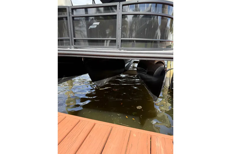 Slide: The Image of 2023 Starcraft EXS 3 Q pontoon boat docked on calm water. - 12