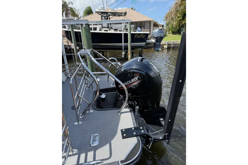 Slide: The Image of 2023 Starcraft EXS 3 Q boat with Mercury outboard motor docked by waterfront. - 14