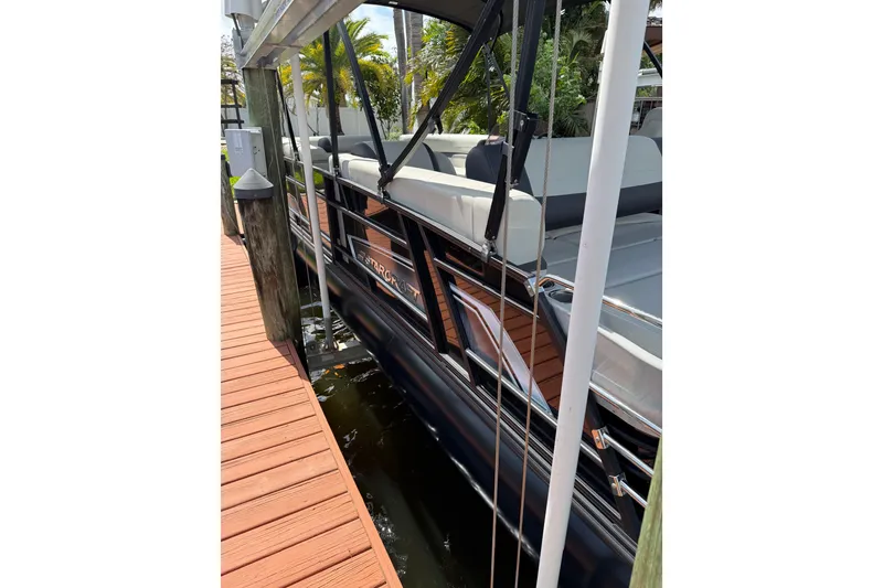 Slide: The Image of 2023 Starcraft EXS 3 Q pontoon boat docked, featuring sleek design and comfortable seating. - 15