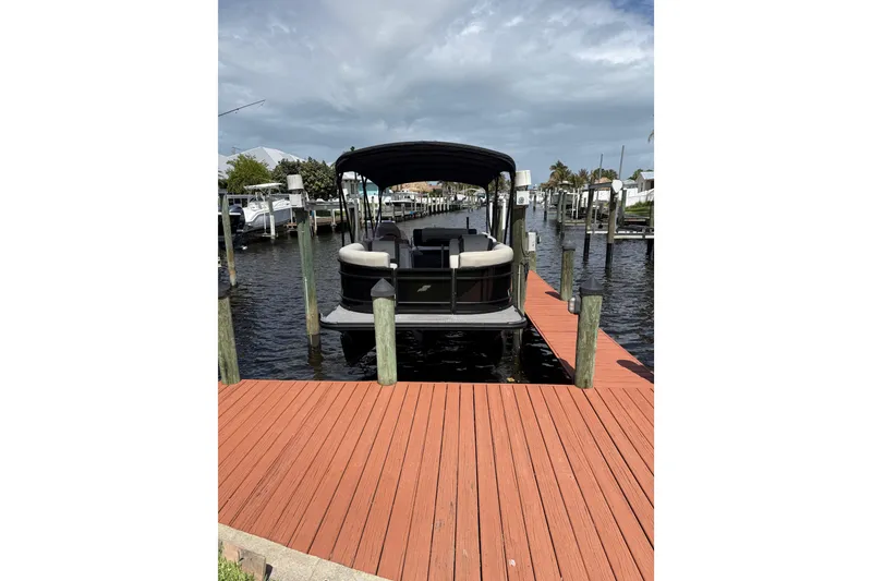 Slide: The Image of 2023 Starcraft EXS 3 Q pontoon boat docked on a sunny day. - 17